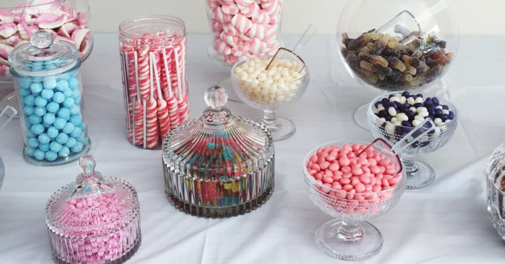 Mesa dulce con tarros de cristal llenos de chuches y golosinas para eventos y celebraciones